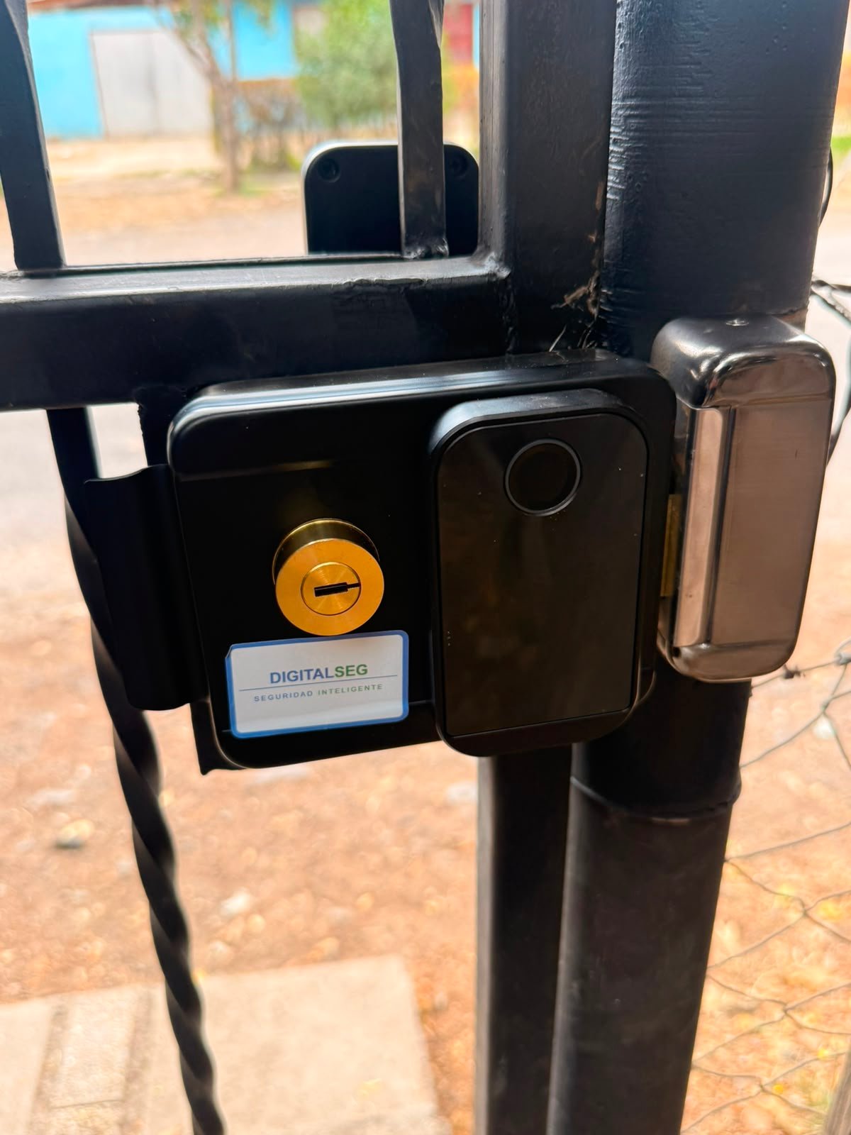 Cerrojo de sobreponer con huella y llave de respaldo instalado en reja metalica
